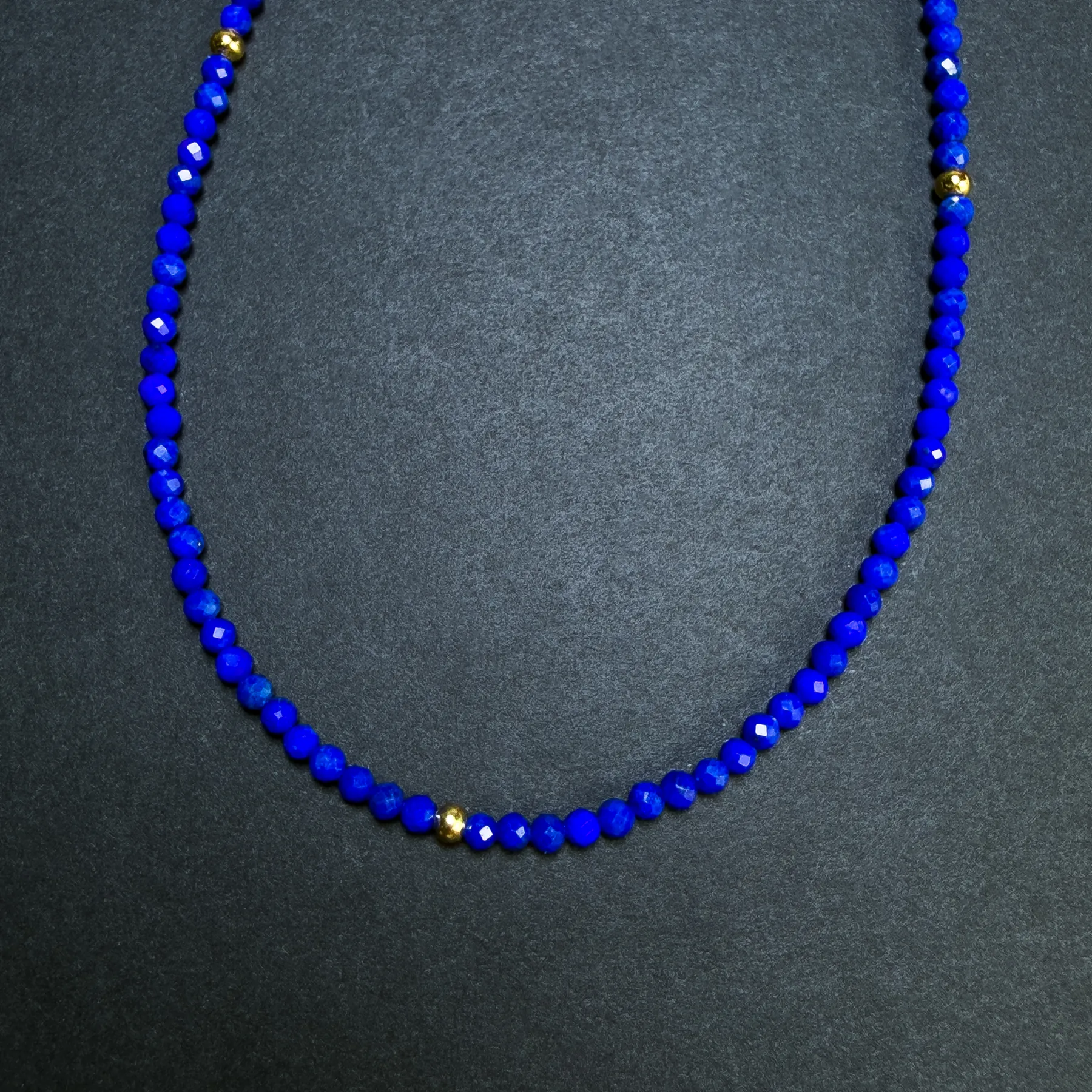 Fine 2 mm faceted blue lapis beads with evenly spaced gold accents