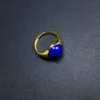 Angled view of an adjustable gold-plated ring with royal-blue lapis lazuli