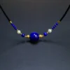 Full adjustable lapis lazuli and pearl necklace arranged on a dark background