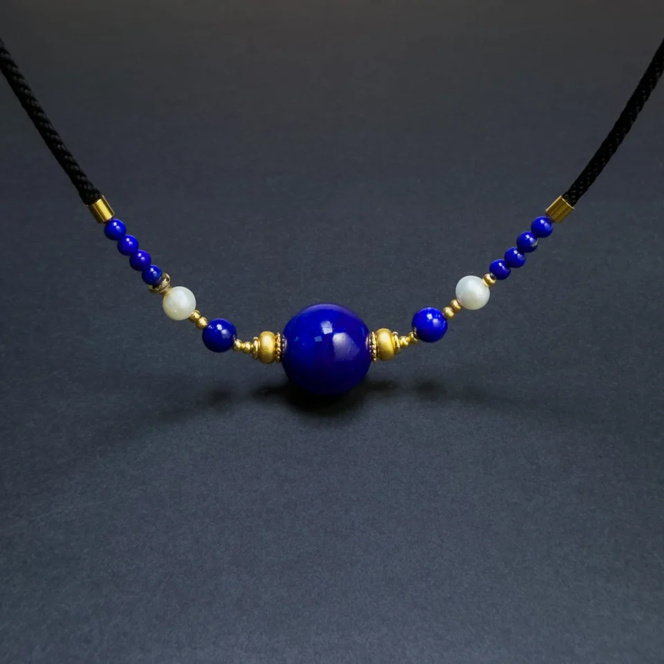 Full adjustable lapis lazuli and pearl necklace arranged on a dark background