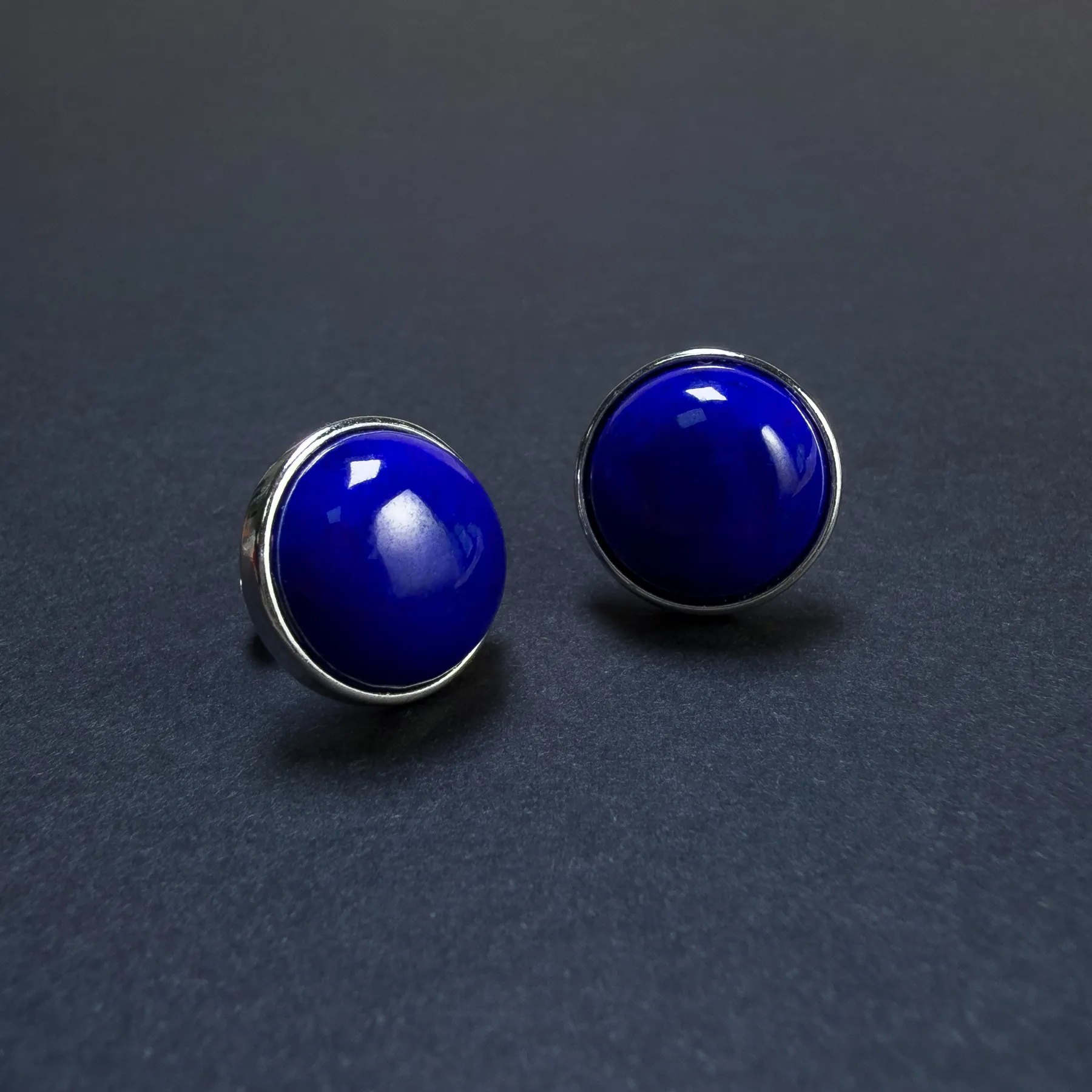 Three-quarter view of high-dome lapis cabochon earrings in S925 silver bezels
