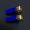 Three-quarter view of blue stone bar earrings with matte gold stud tops