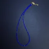 Angled full view of a cobalt blue lapis bead necklace with small gold beads
