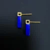 Angled back view of vivid blue lapis bars beneath matte gold studs