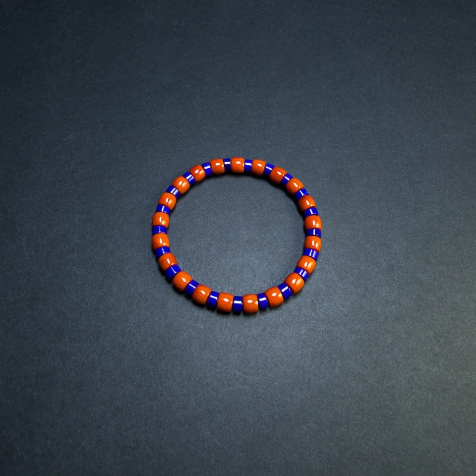 Full overhead view of the blue and orange-red elastic gemstone bracelet