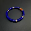 Overhead blue and red gemstone bracelet with gold-tone cubic zirconia spacers