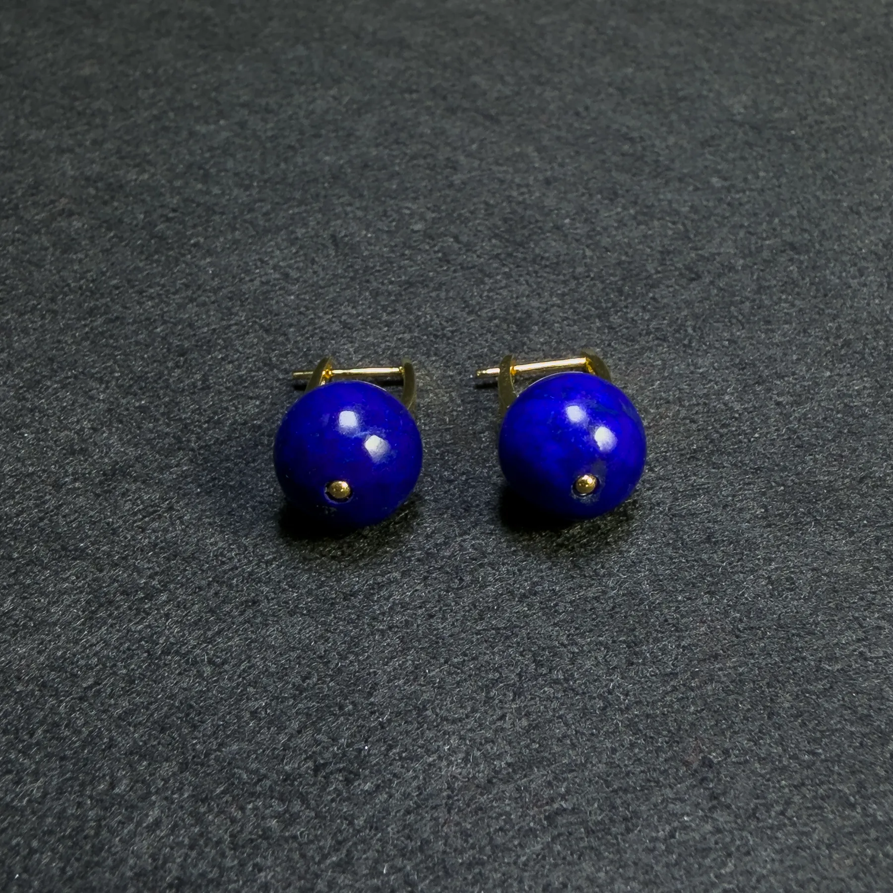 Close view of deep-blue round lapis beads with gold-tone leverbacks