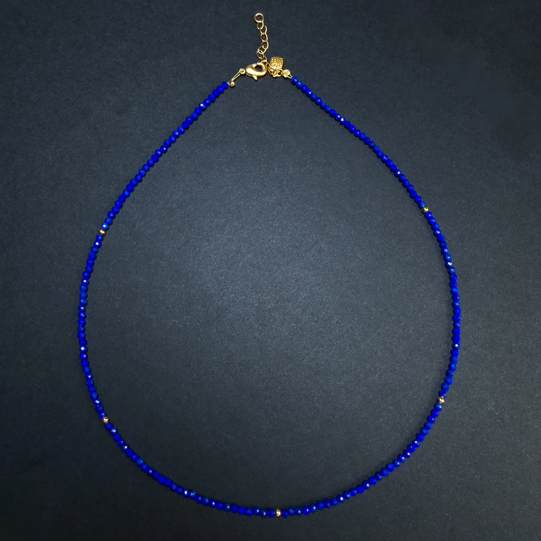 Complete delicate lapis lazuli micro bead necklace on a dark background