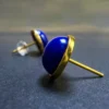 Domed lapis cabochon earrings viewed closely from the side