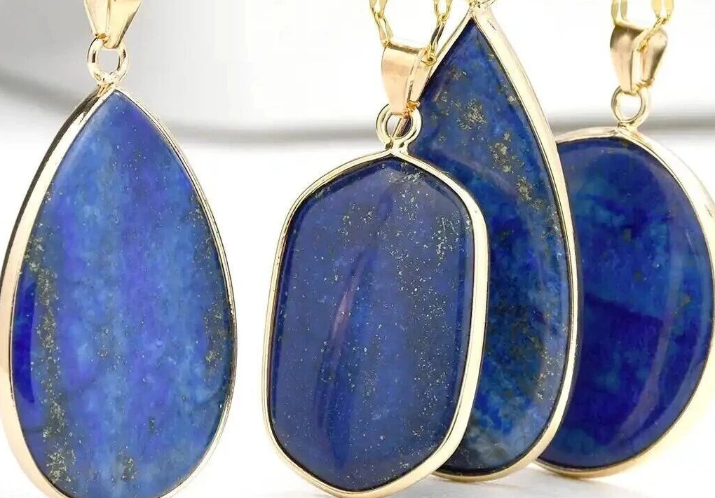 Four gold-tone lapis pendants with varied blue mineral patterns