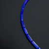 Overhead detail of imperial-blue lapis column beads aligned on black