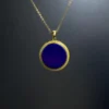 Full view of imperial-blue round lapis pendant suspended from gold-plated chain