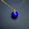 Close view of imperial-blue lapis pendant with decorative gold-tone bead cap