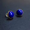 Close angled view of polished imperial-blue lapis stud earrings