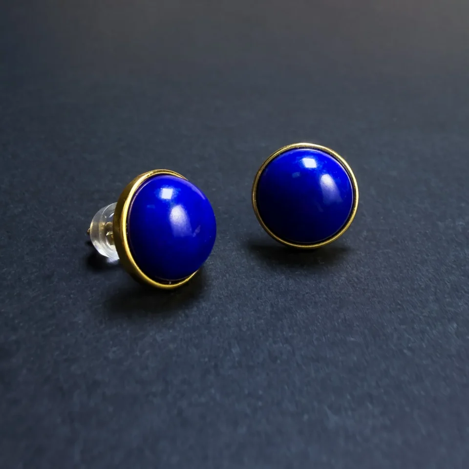 Close angled view of polished imperial-blue lapis stud earrings