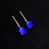 Deep blue cube earrings with slender silver bars on black velvet