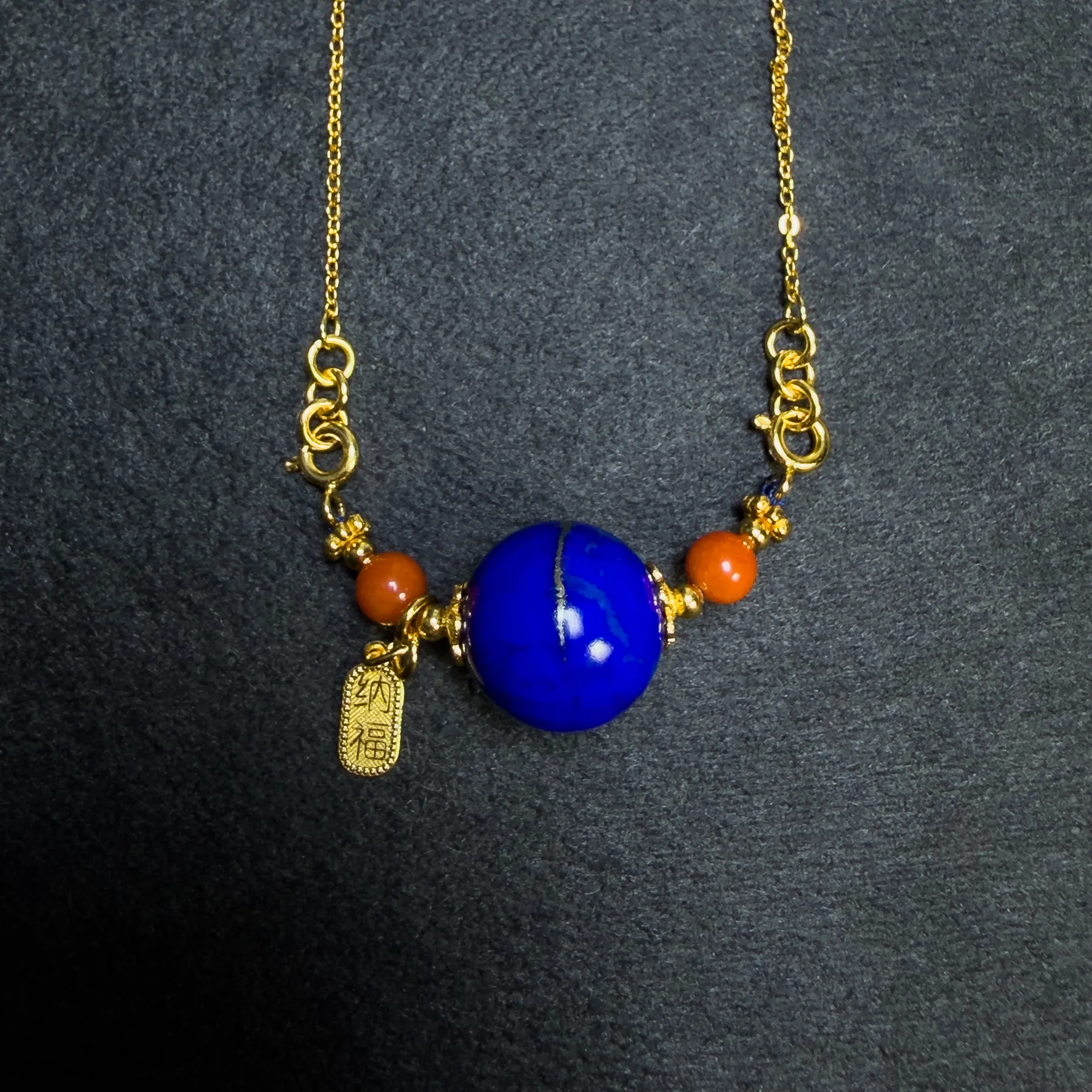 Front detail of imperial-blue lapis pendant with golden mineral ring