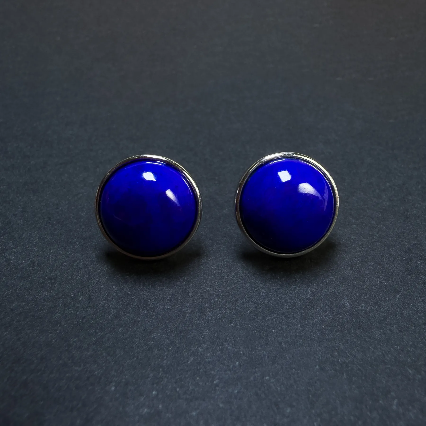 Front view of round Imperial lapis lazuli stud earrings in silver bezel settings