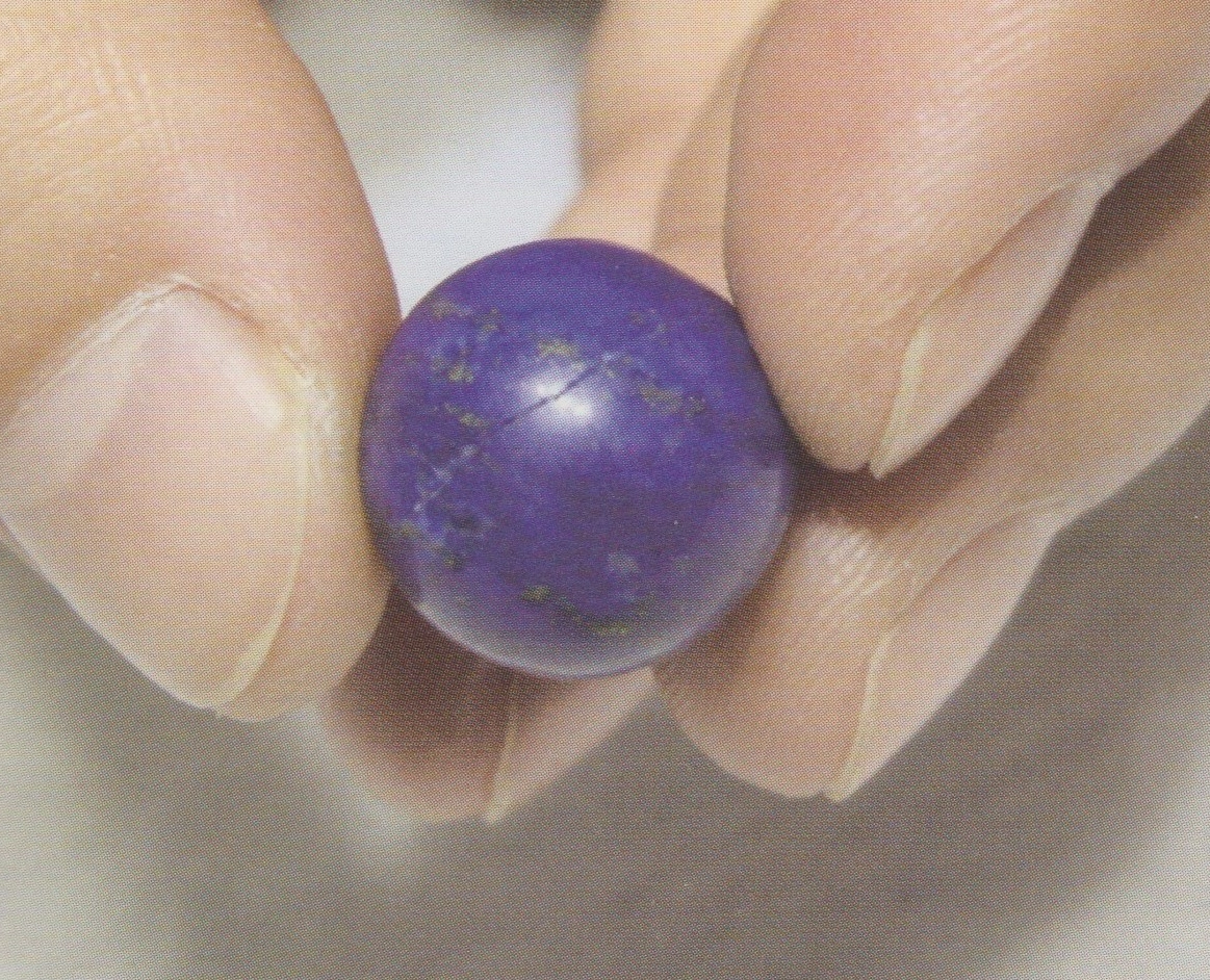 Single polished blue bead with fine golden flecks and surface line