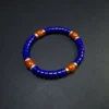 Angled lapis heishi bracelet with four red agate accents and gold spacers
