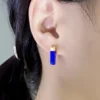 Cobalt blue lapis lazuli bar earring worn vertically on the earlobe