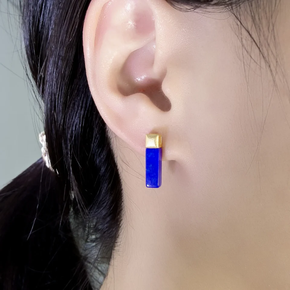 Cobalt blue lapis lazuli bar earring worn vertically on the earlobe