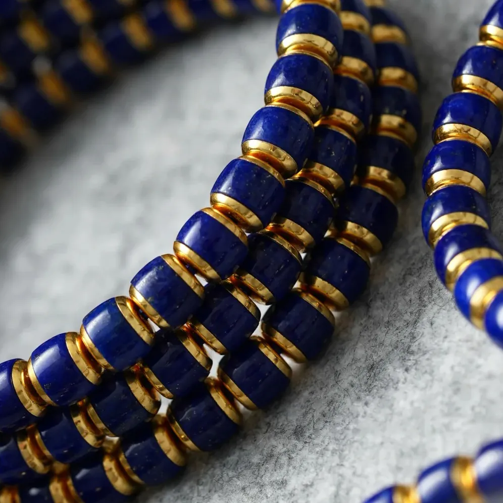 Close-up of stacked lapis lazuli bracelets with blue beads and gold-tone spacers