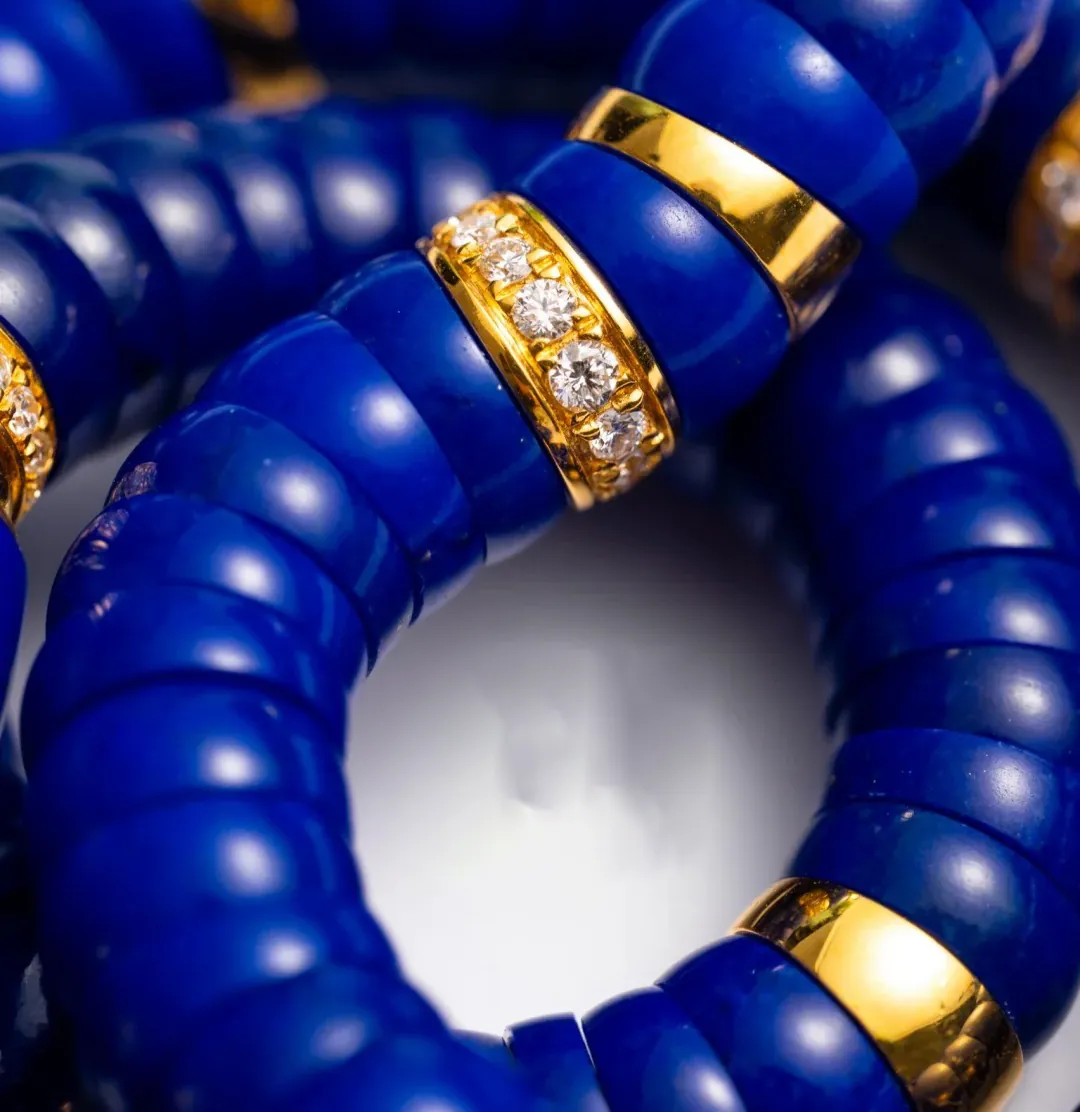 Macro view of polished blue lapis lazuli bracelet beads with gold-tone accents