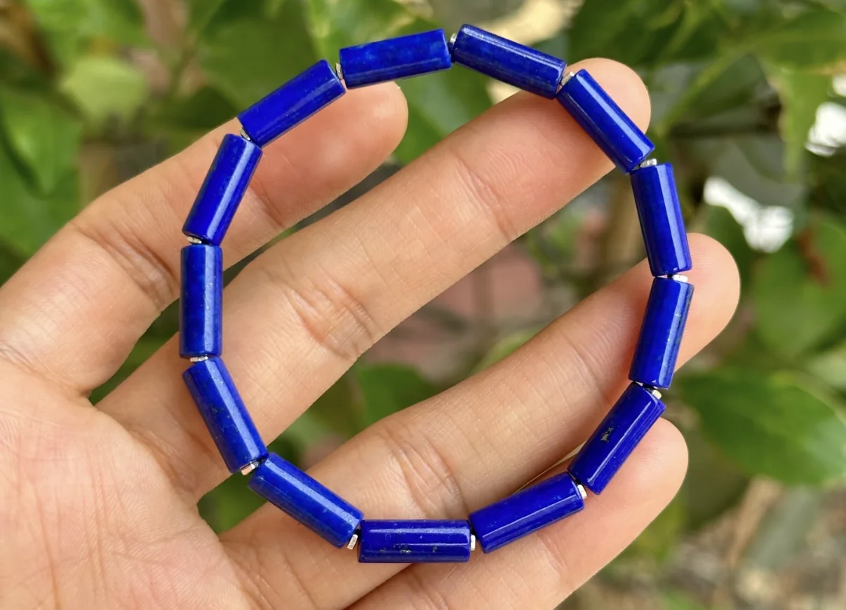 Rectangular lapis lazuli bead bracelet held in hand outdoors