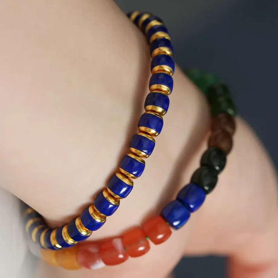 Two lapis lazuli bracelets worn on a wrist with blue beads and gold-tone accents