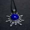 Close angled view of polished lapis lazuli cabochon and silver sun rays