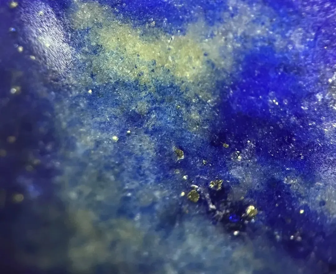 Close-up of pale calcite and small mineral details within blue lapis lazuli