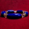 Close-up front view of polished blue lapis lazuli and clear quartz bracelet