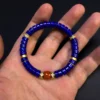 Lapis lazuli heishi bracelet held across an open hand for scale