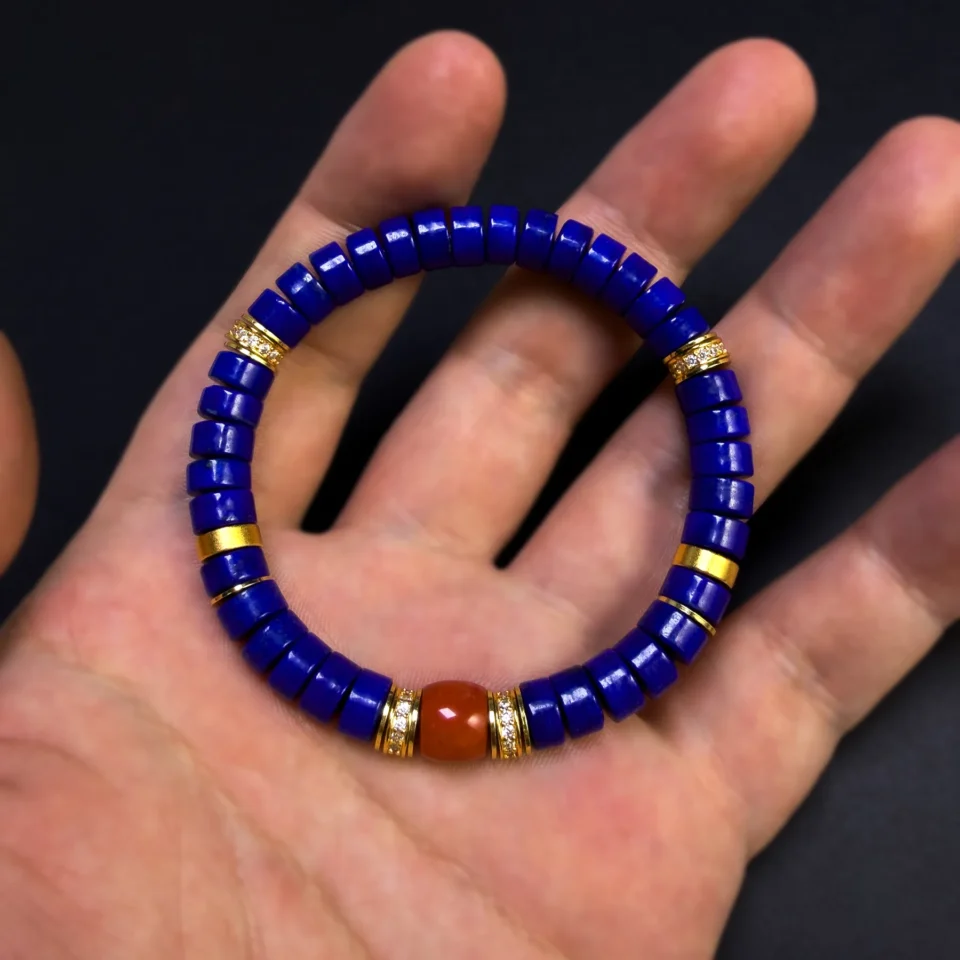 Lapis lazuli heishi bracelet held across an open hand for scale