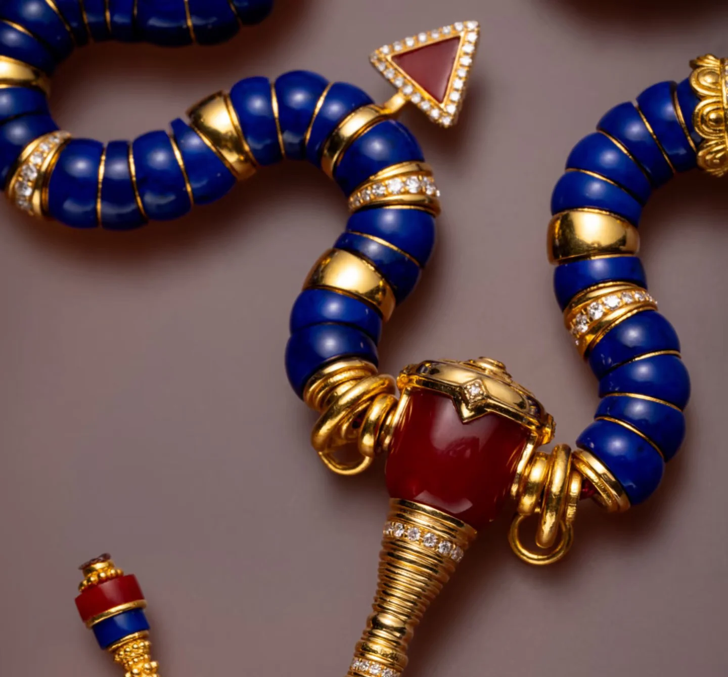 Lapis lazuli necklace and bracelets arranged with blue, gold and red accents