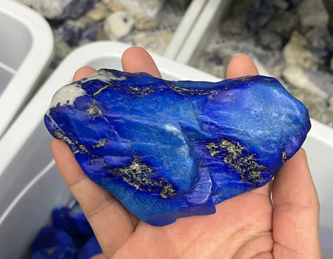 Rough lapis lazuli specimen showing blue lazurite, pale calcite and gold-colored pyrite