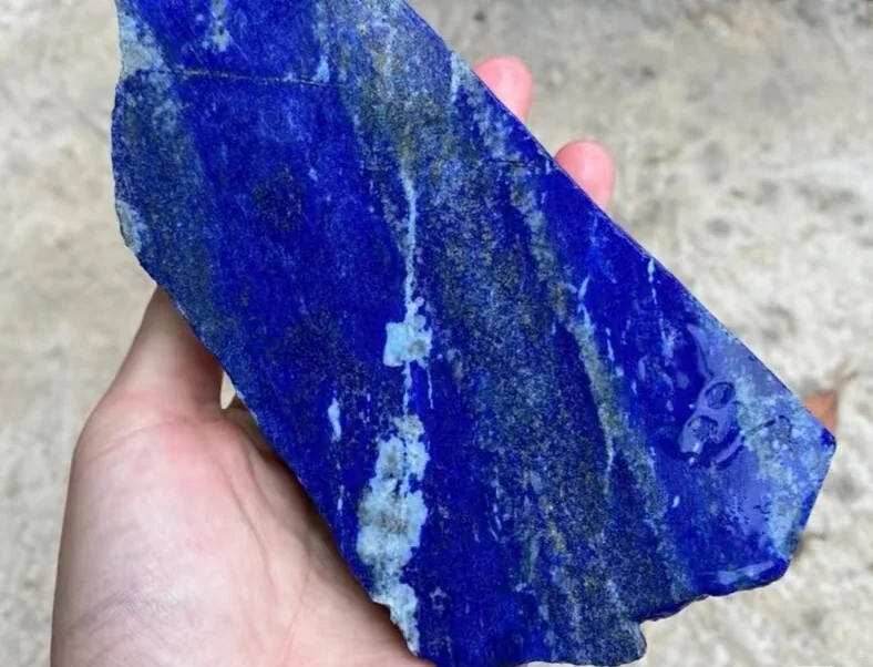 Polished lapis lazuli showing deep blue color, white calcite and golden pyrite