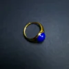 Side view of the gold-tone open band and blue lapis lazuli stone