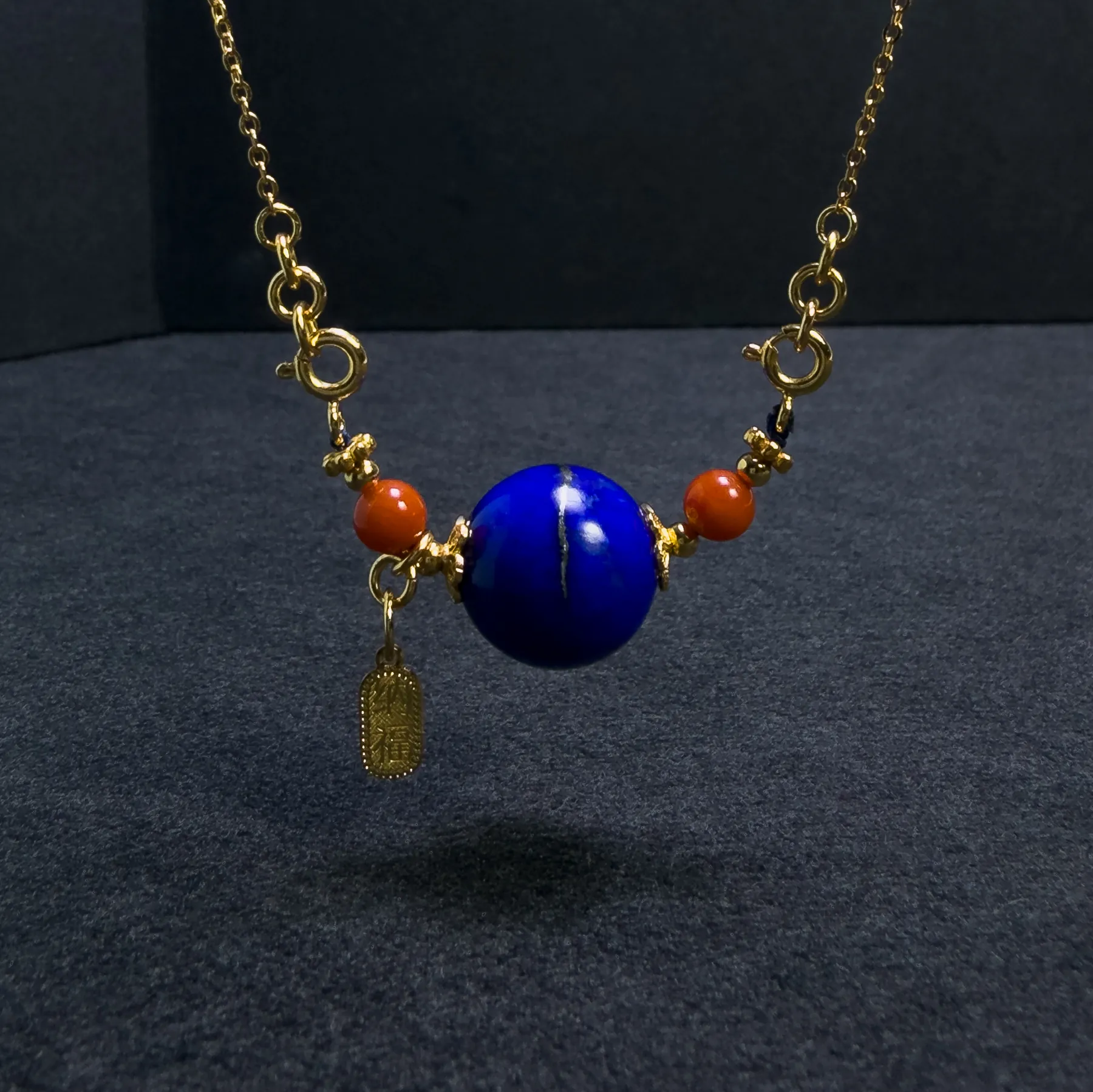 Hanging lapis lazuli planet pendant with red agate beads and gold charm