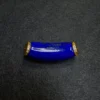 Close-up of a curved lapis lazuli component with natural pyrite flecks and gold-plated spacer details