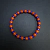 Close-up of royal blue lapis lazuli and orange-red agate barrel beads
