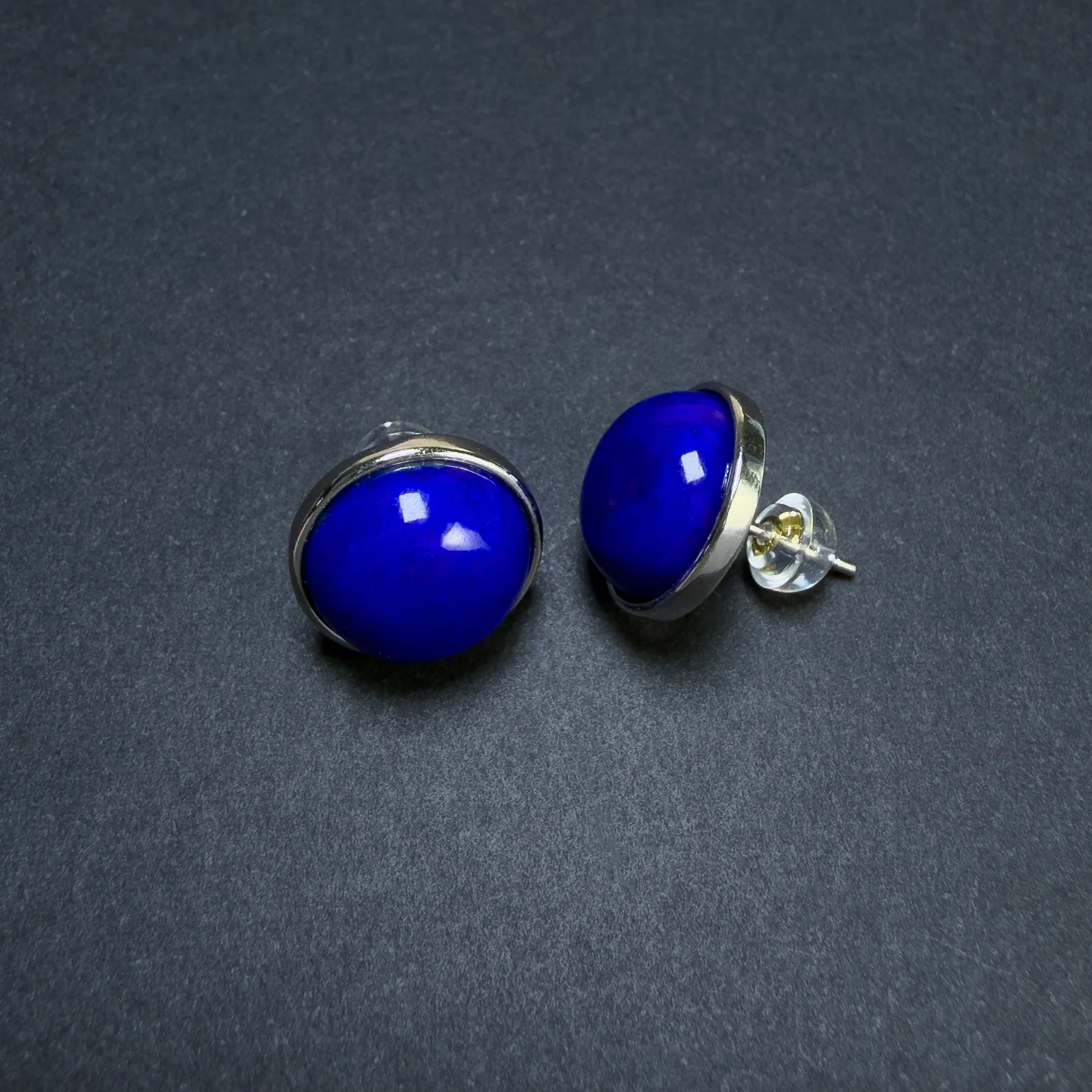 Front and side view showing blue lapis studs, silver bezels and an earring back