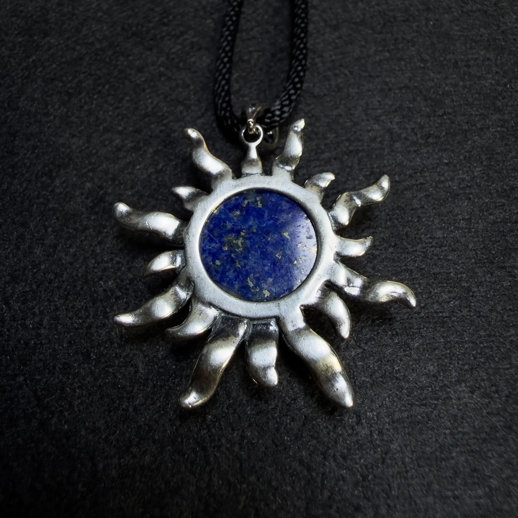 Back view of lapis lazuli sun pendant with natural stone markings