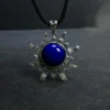 Upright lapis lazuli sun pendant displayed against a dark gray background