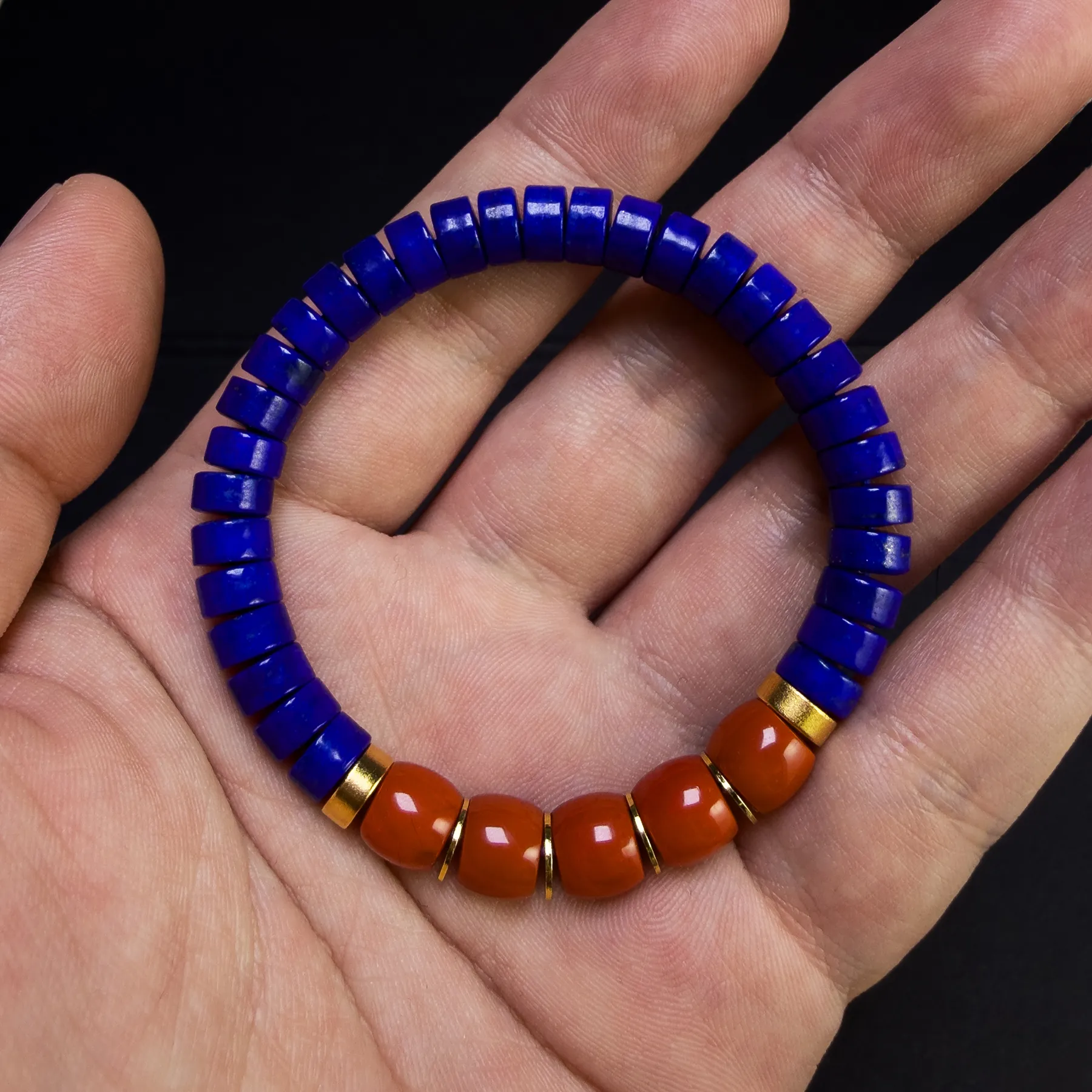 Lapis and Nanhong heishi bracelet held across an open hand for scale