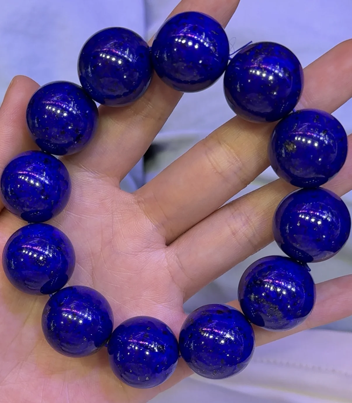 Large round lapis lazuli bead bracelet held in hand
