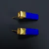 Profile view of two lapis bar earrings with matte gold geometric settings