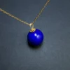 Minimalist round lapis lazuli pendant viewed at a close diagonal angle