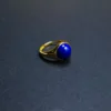 Low-angle view of a minimalist lapis lazuli ring with gold-tone band